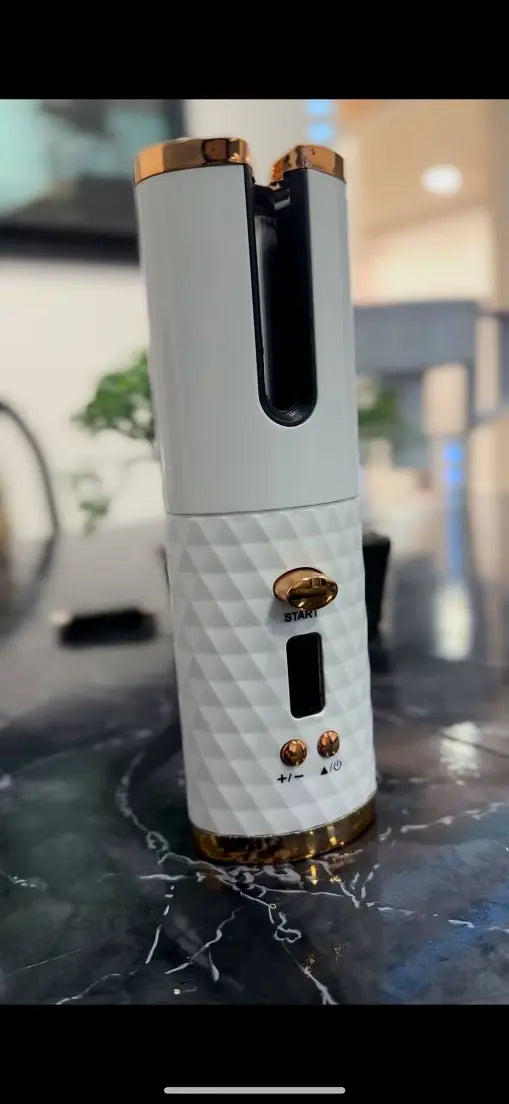 White electronic device with gold accents on a reflective surface